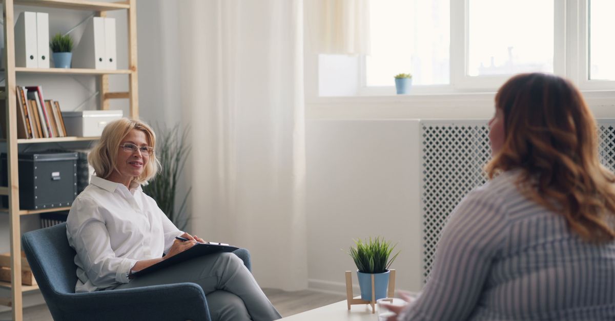 A therapist listening to a client in a bright, calm Cerritos office